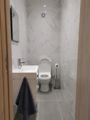 a white bathroom with a toilet and a sink at Martins 3 Bedroom Flat in Larnaka