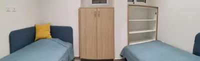 a bedroom with a blue couch and a cabinet at Martins 3 Bedroom Flat in Larnaka