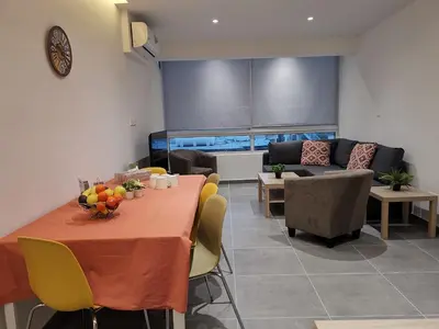 a living room with a table and a couch at Martins 3 Bedroom Flat in Larnaka