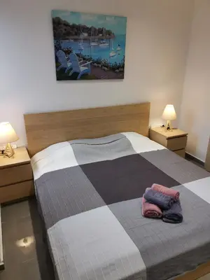 a bedroom with a bed with two lamps and two towels at Martins 3 Bedroom Flat in Larnaka
