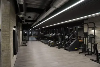 a gym with a row of treadmills and machines at Rooftop Sunset Garden by Staycom in Pamboula
