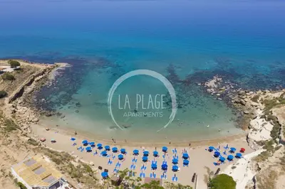 an aerial view of a beach with umbrellas and the sign at Cosy 2Br Family Apartment - Mythical Sands Resort in Paralimni