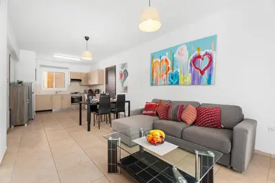a living room with a couch and a table at Cosy 2Br Family Apartment - Mythical Sands Resort in Paralimni