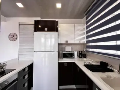 a kitchen with a white refrigerator and a microwave at STAY NEO Coast Apartment in Limassol
