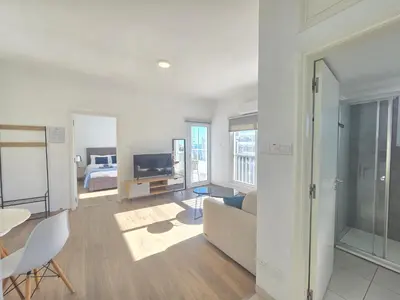 a white living room with a couch and a bed at 1 bd at Mediterranean Beach - Limassol Bay B206 in Limassol