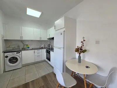 a kitchen with a table and a white refrigerator at 1 bd at Mediterranean Beach - Limassol Bay B206 in Limassol