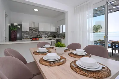 a kitchen and dining room with a wooden table and chairs at Villa Brigita in Ayia Napa