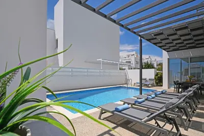 a swimming pool with lounge chairs on the roof of a building at Villa Brigita in Ayia Napa
