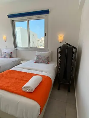 two twin beds in a room with a window at Mangoes & Cherries in Ayia Napa