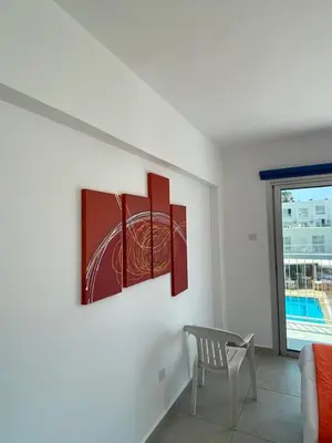 a living room with three paintings on the wall at Mangoes & Cherries in Ayia Napa