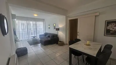 a living room with a table and a blue couch at STAY Elion Apartment in Nicosia