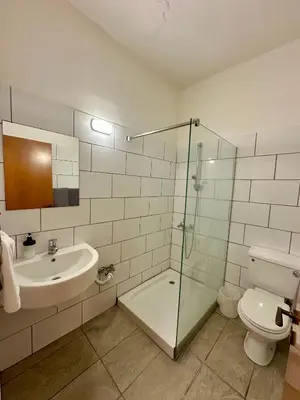 a bathroom with a shower and a sink and a toilet at Ellis Hotel Apartments in Larnaka