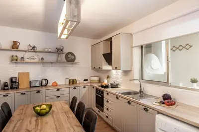 a kitchen with white cabinets and a wooden table at Galata Watermill Cottage in Nicosia