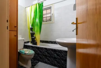 a bathroom with a green shower curtain and a toilet at Martin 2 bed Apartment in Larnaka