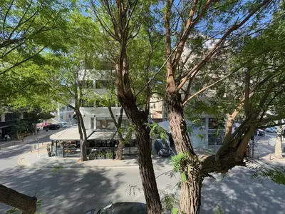 a tree in front of a building on a street at Stasandrou City Center Residence in Nicosia