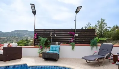 a patio with two chairs and a bench next to a pool at Villa Althea, Pool, Mountain Views, BBQ ,Patio in Laneia in Lania
