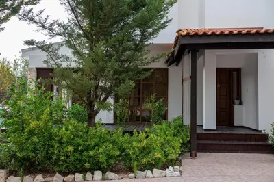 a small white house with a tree in front of it at Villa Althea, Pool, Mountain Views, BBQ ,Patio in Laneia in Lania