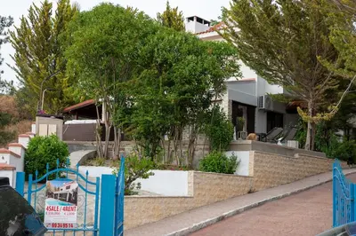 a house with a blue fence and trees at Villa Althea, Pool, Mountain Views, BBQ ,Patio in Laneia in Lania