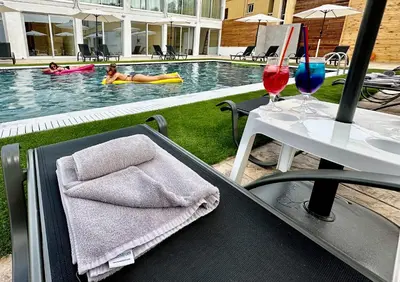 a pool with a table with a towel and wine glasses at NÓA Rooms - Adults Only in Ayia Napa