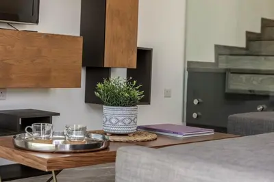 a coffee table with glasses and a potted plant on it at Sam's Villa in Paralimni