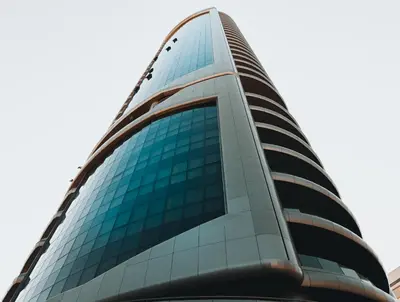 a tall glass office building with blue windows at The 1 -Nicosia Elite Stay- Gym Pool 24h Concierge in Nicosia