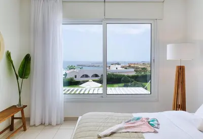a bedroom with a large window with a view at Sirena Solis Villa - Elegant 5-bedroom Sea View Retreat near Sirena Bay in Protaras