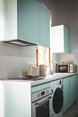 a kitchen with blue cabinets and a washing machine at Althaea Mare in Lofou