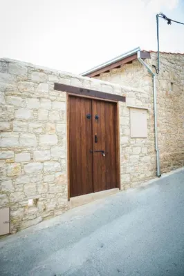 a stone building with a wooden door on it at Althaea Mare in Lofou