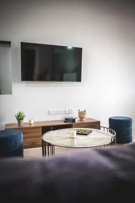 a living room with a table and two chairs and a tv at Althaea Mare in Lofou