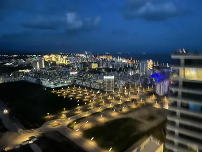 a view of a city at night with lights at Grand Sapphire Resort in Aglantzia