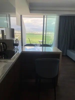a kitchen with a counter with chairs and a view at Grand Sapphire Resort in Aglantzia