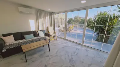 a living room with a couch and a large window at STAY The Getaway Apartment in Pyla