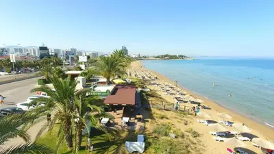 a beach with a bunch of umbrellas and the ocean at Cheap Holiday Opportunity in North Cyprus in Larnaka