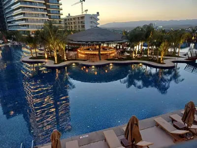 a large swimming pool with chairs and a building at Grand Saphire Resort Apartment-I in İskele