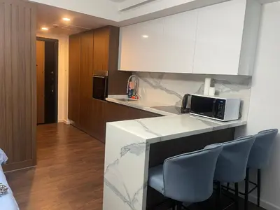 a kitchen with a counter with chairs and a microwave at Grand Sapphire Resort in Aglantzia