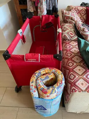 a red suitcase on wheels next to a bed at 2 Bed Apartment Pool and Sea Views in Oroklini in Voroklini