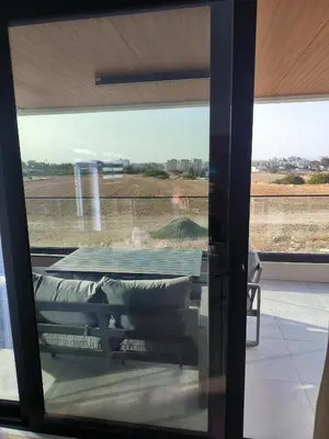 a view of a table through a glass door at 2 Bedroom Brand New Apartment Mc Kenzie 2 minute to the Mc Kenzie Beach in Larnaka
