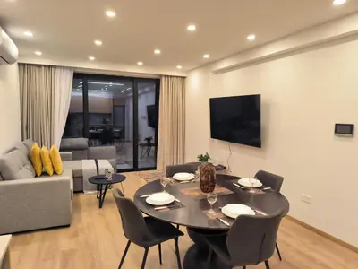 a living room with a table and chairs and a television at 2 Bedroom Brand New Apartment Mc Kenzie 2 minute to the Mc Kenzie Beach in Larnaka