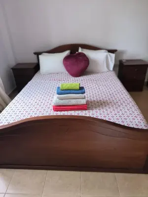 a bed with three towels on it with a heart pillow at 3 Bedroom Affordable Apartment in Oroklini with Communal Pool in Voroklini