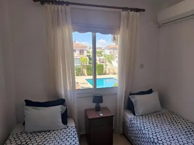 a bedroom with two beds and a window with a pool at 3 Bedroom Affordable Apartment in Oroklini with Communal Pool in Voroklini