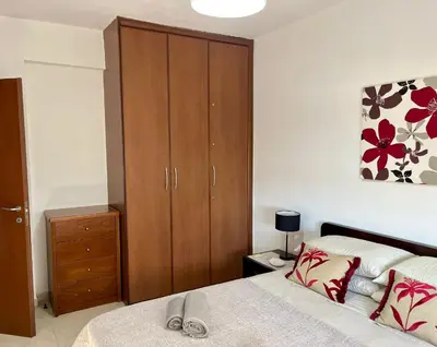 a bedroom with a bed and a wooden cabinet at 2 Bedroom Penthouse Apartment in Oroklini with Communal Pool in Voroklini