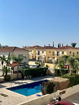a swimming pool in front of some apartment buildings at 2 Bedroom Penthouse Apartment in Oroklini with Communal Pool in Voroklini