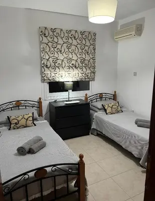 two twin beds in a room with a window at 2 Bedroom Penthouse Apartment in Oroklini with Communal Pool in Voroklini