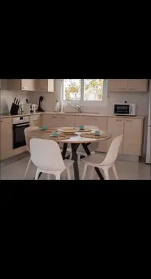 a kitchen with a wooden table and white chairs at MERAKI Villa in Paralimni