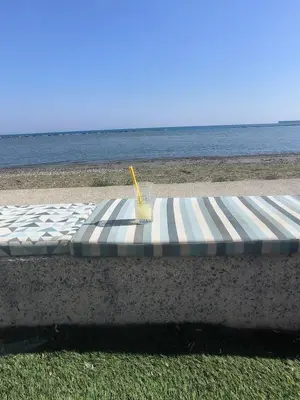 a mattress on the beach with a drink on it at Superior 1 bed apartment in Oroklini with Communal Pool in Voroklini