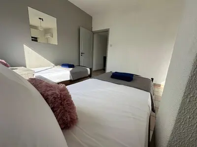a room with two beds and a mirror at Adonis Holiday Apt - Nicosia in Nicosia