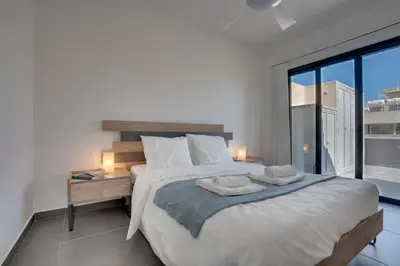 a bedroom with a large bed and a large window at Makenzy Star 2bd duplex 300m from beach in Larnaka