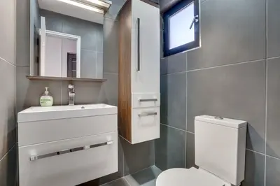 a bathroom with a toilet and a sink and a mirror at Makenzy Star 2bd duplex 300m from beach in Larnaka