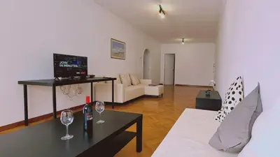 a living room with a couch and a table with wine glasses at STAY Virtuoso Apartment in Nicosia