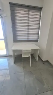 a white desk with a chair and a window at RIVERA Studios 1 in Limassol